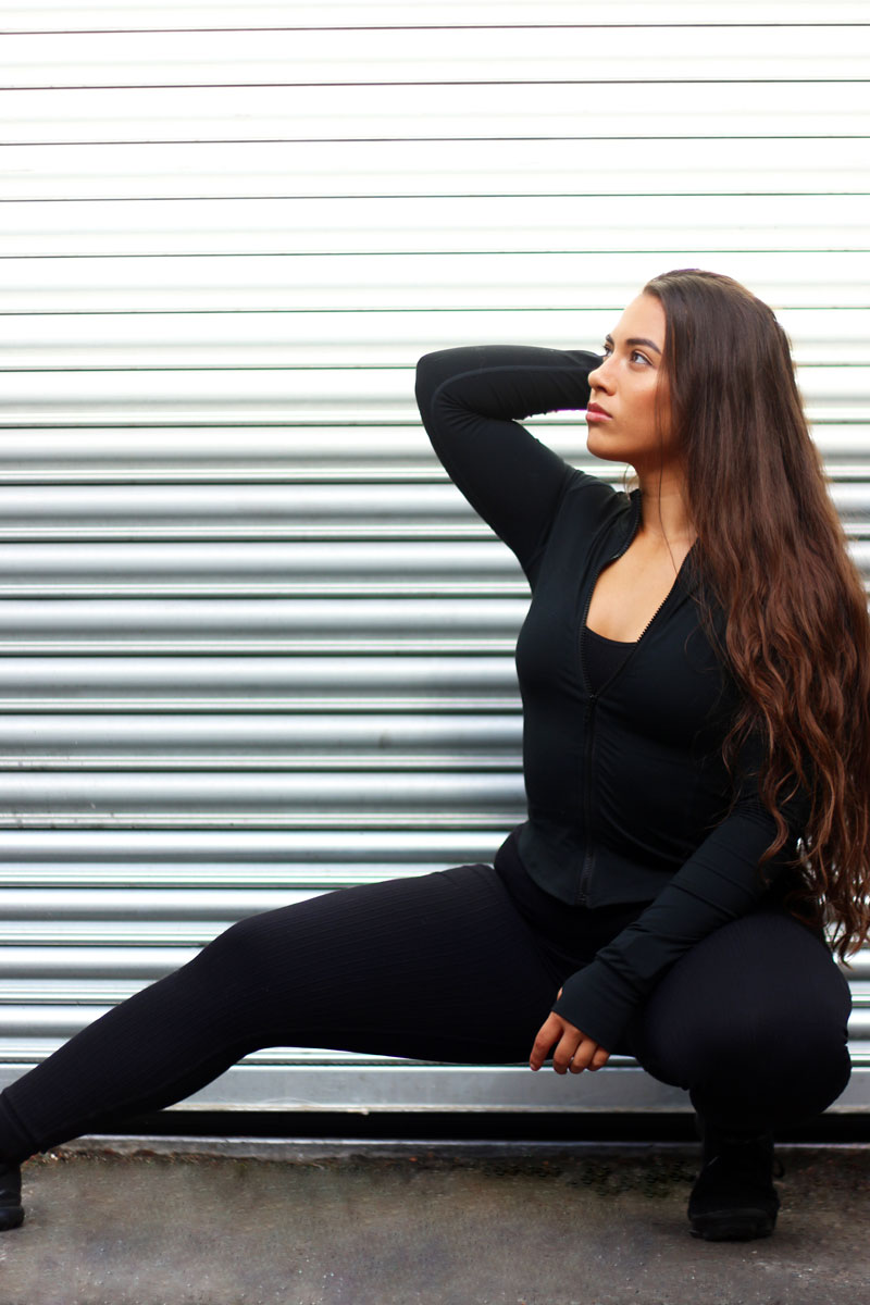 The coach is posing while she is stretching.